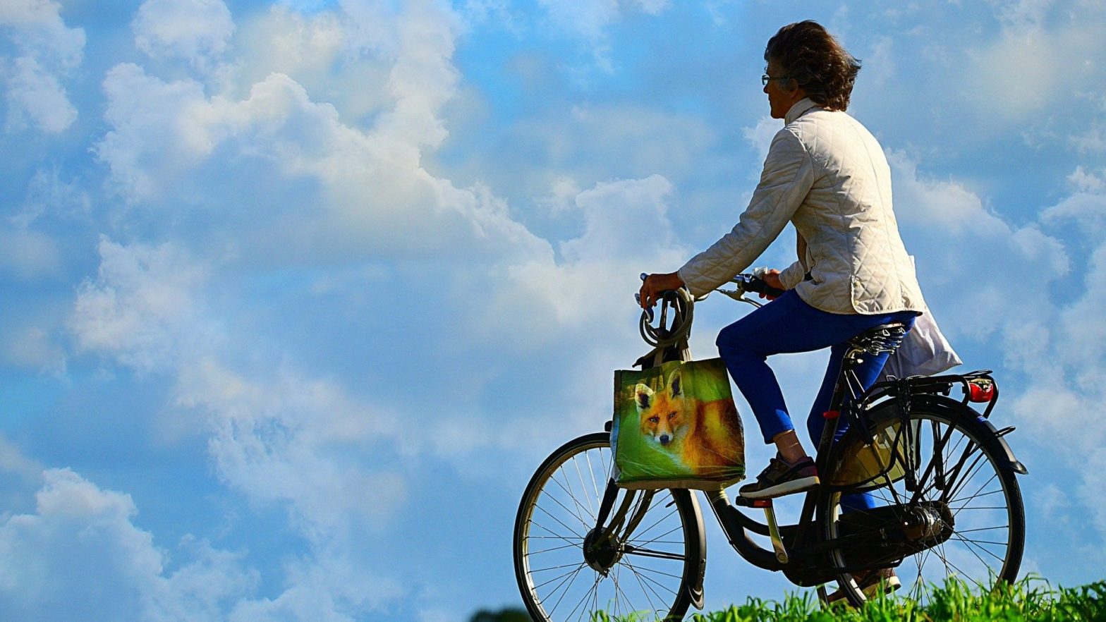 Mulher andando de bicicleta ao ar livre.