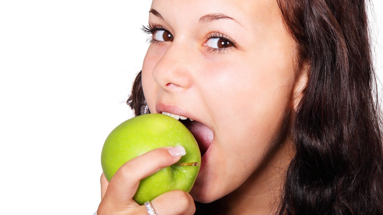 Mulher mordendo maçã verde.