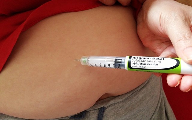 Mulher aplicando a injeção de insulina no abdomên.