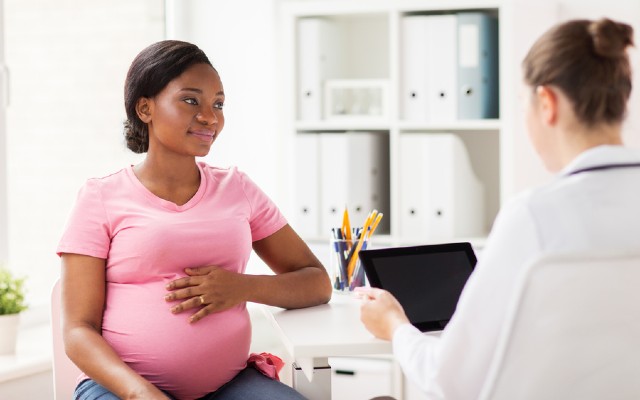 Mulher grávida durante consulta com obtetrica sobre o uso do misoprostol.