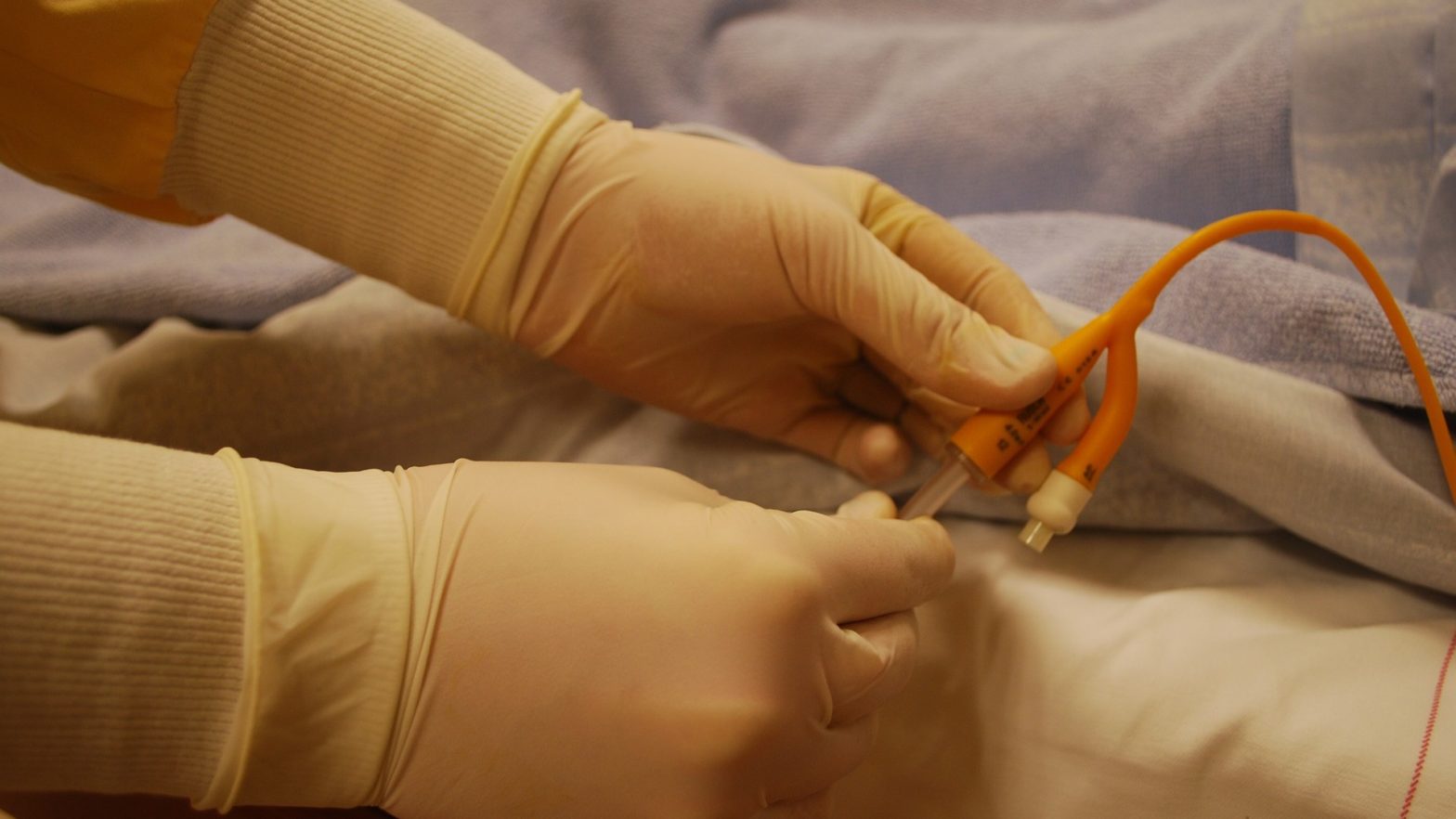Médica cardiologista regulando um cateter utilizado para o exame de cateterismo no paciente.