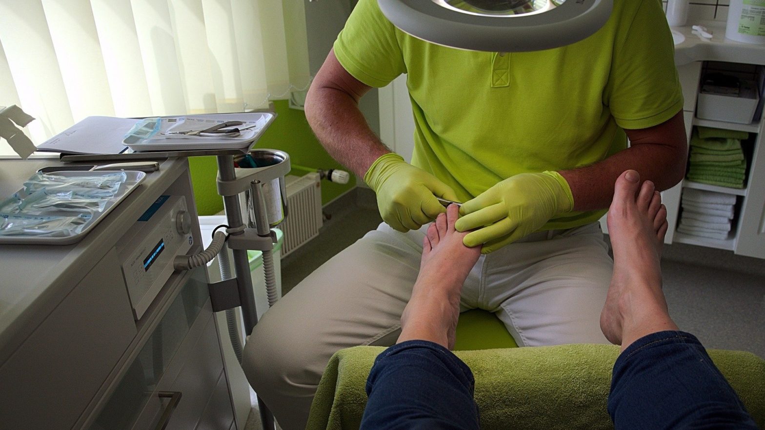 Podólogo realizando uma avaliação nos pés de um paciente no consultório.